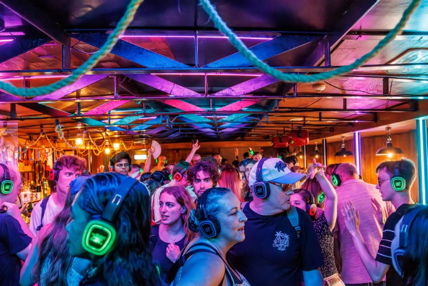 people in an encolsed space dancing, blue lights on them